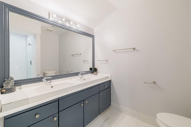 bathroom with vanity, vaulted ceiling, and toilet