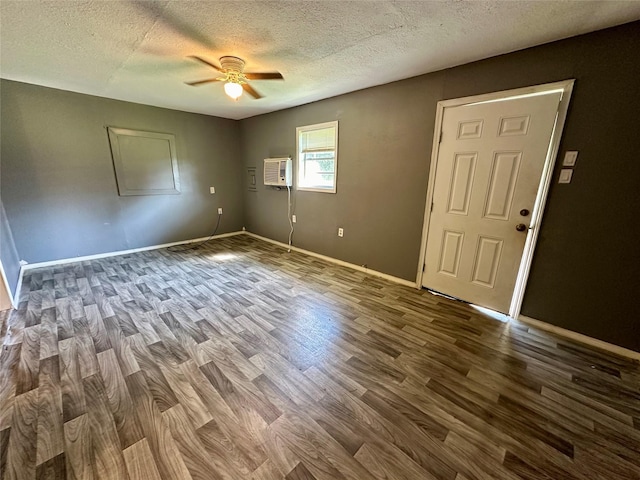 empty room featuring a wall mounted AC, ceiling fan, a textured ceiling, and hardwood / wood-style flooring