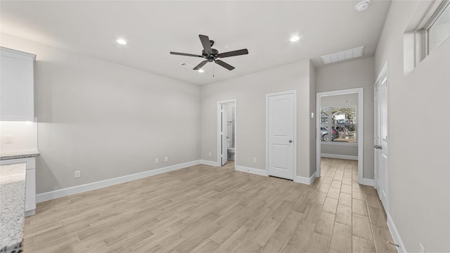 interior space featuring ensuite bath, light hardwood / wood-style flooring, and ceiling fan