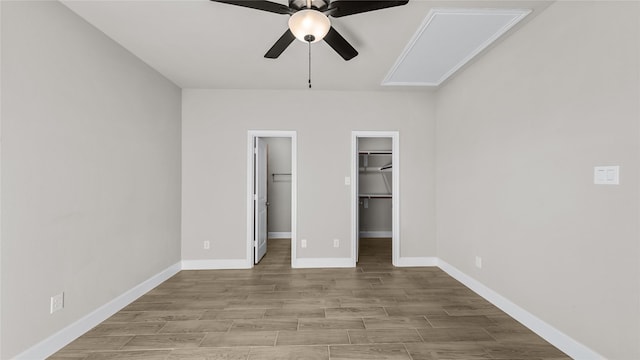 unfurnished bedroom featuring ceiling fan, a walk in closet, and a closet