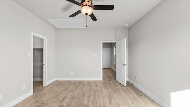 unfurnished bedroom with ceiling fan, light wood-type flooring, a spacious closet, and a closet