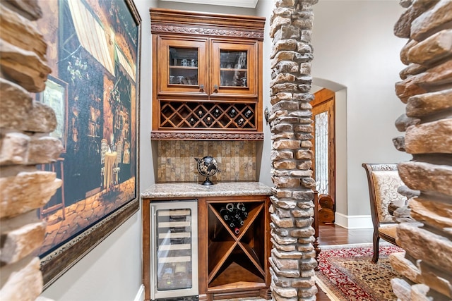 wine room featuring wine cooler and dark wood-type flooring