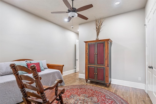 living area featuring light hardwood / wood-style floors and ceiling fan