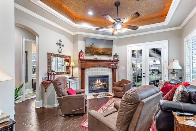 living room with french doors, a wealth of natural light, ornamental molding, a raised ceiling, and ceiling fan