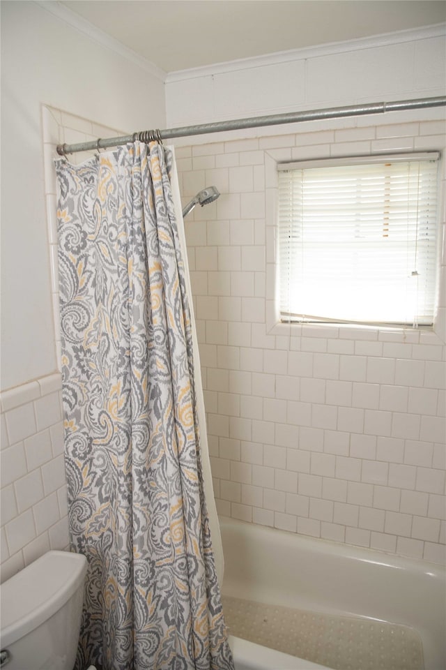 bathroom with crown molding, tile walls, shower / bath combination with curtain, and toilet