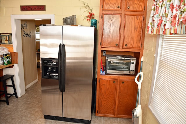 kitchen with stainless steel refrigerator with ice dispenser and light tile patterned floors