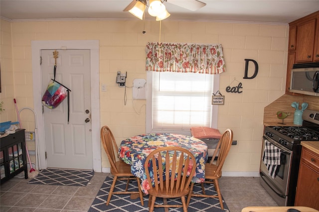 dining space with crown molding, ceiling fan, and tile patterned floors