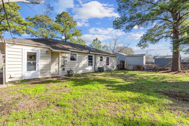 rear view of property featuring a yard and central AC