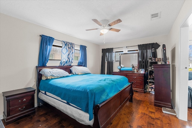 bedroom featuring ceiling fan, dark hardwood / wood-style flooring, and a textured ceiling