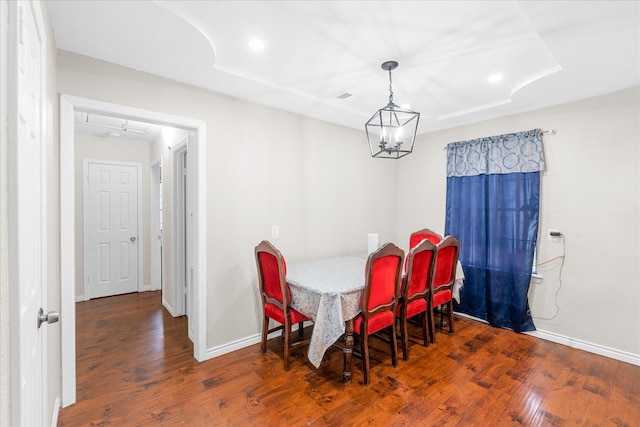 dining space with dark hardwood / wood-style floors and ceiling fan with notable chandelier