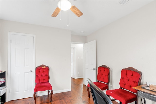 living area featuring dark hardwood / wood-style flooring and ceiling fan