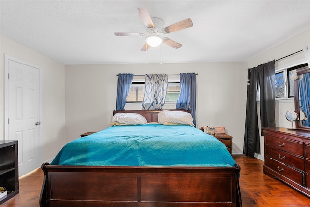 bedroom featuring ceiling fan, dark hardwood / wood-style floors, and a textured ceiling