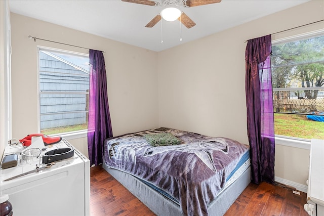 bedroom with multiple windows, ceiling fan, and dark wood-type flooring