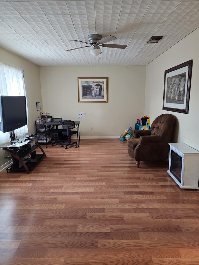 living area featuring ceiling fan and wood-type flooring