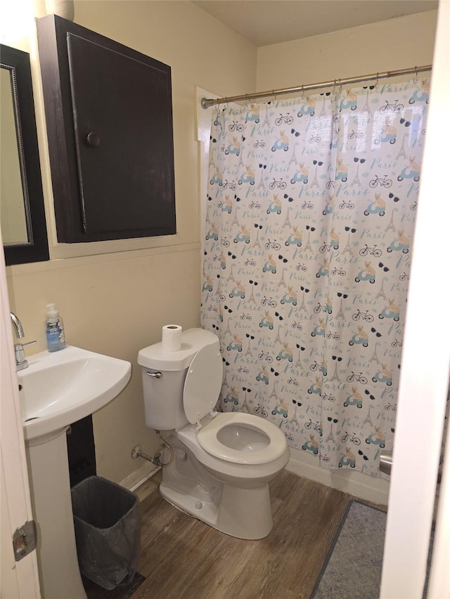 bathroom with shower / bathtub combination with curtain, toilet, and wood-type flooring