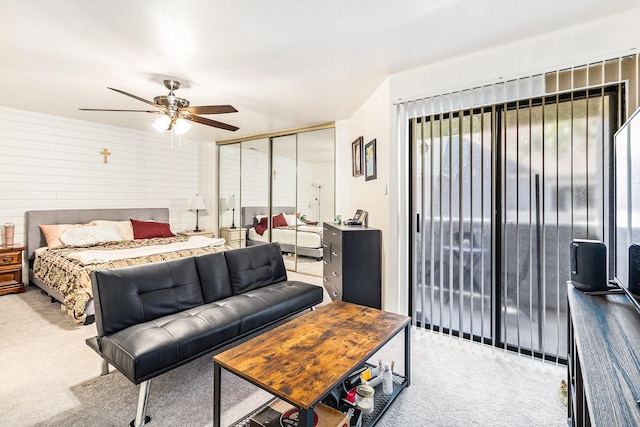 carpeted bedroom with a closet, ceiling fan, and access to outside