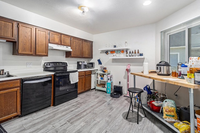 kitchen with sink, black appliances, and light hardwood / wood-style flooring