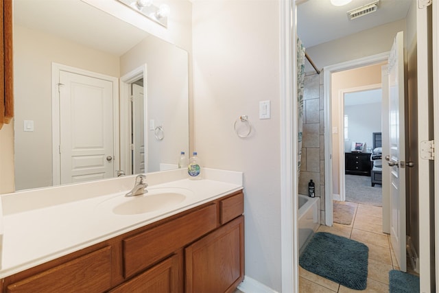 bathroom with tile patterned floors, vanity, and tiled shower / bath combo