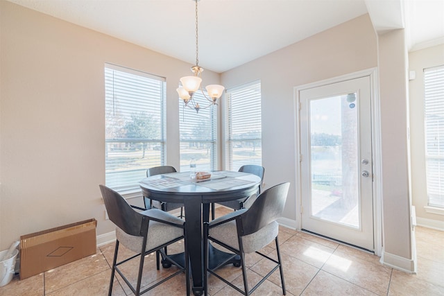 dining room with light tile patterned floors and an inviting chandelier