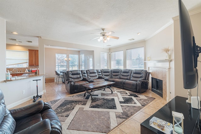 tiled living room with plenty of natural light, a textured ceiling, and a tile fireplace