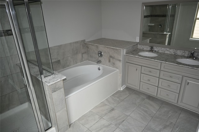 bathroom with tile patterned floors, vanity, and shower with separate bathtub