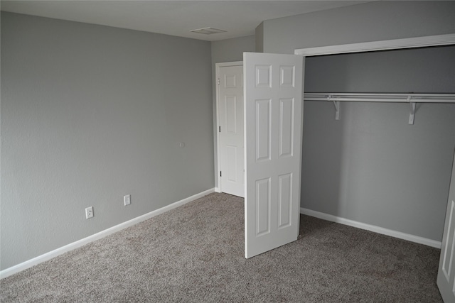 unfurnished bedroom featuring a closet and dark carpet