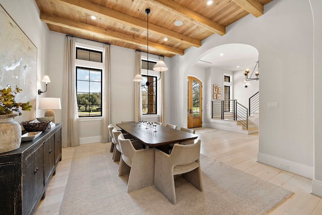 dining space with wood ceiling, light hardwood / wood-style flooring, and beam ceiling