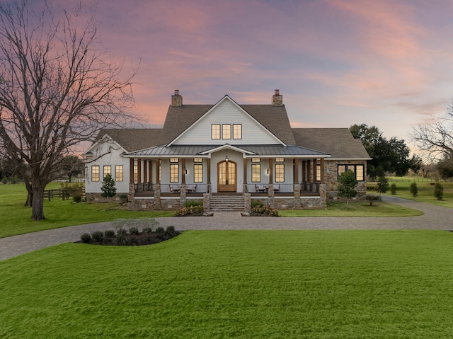 view of front facade featuring covered porch and a lawn