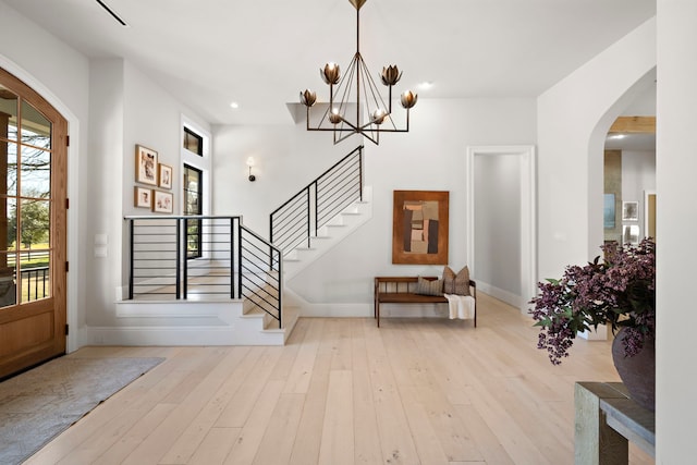 foyer entrance with light hardwood / wood-style floors and a notable chandelier