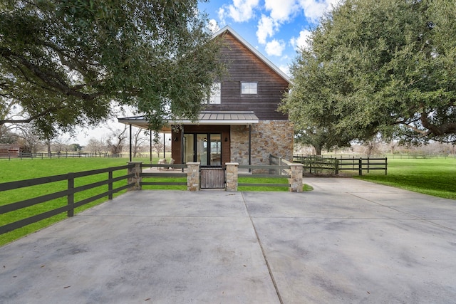 view of front of property with a front yard and a rural view