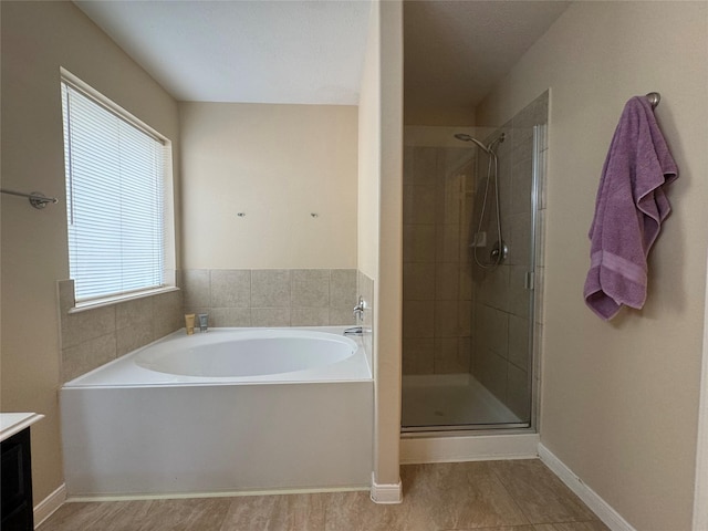 bathroom with tile patterned floors, plus walk in shower, vanity, and a healthy amount of sunlight