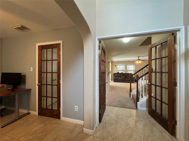 hall featuring french doors and light tile patterned floors