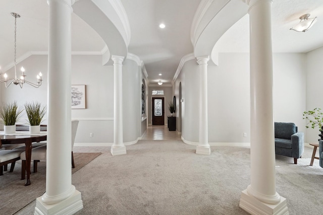 carpeted foyer featuring an inviting chandelier and ornamental molding