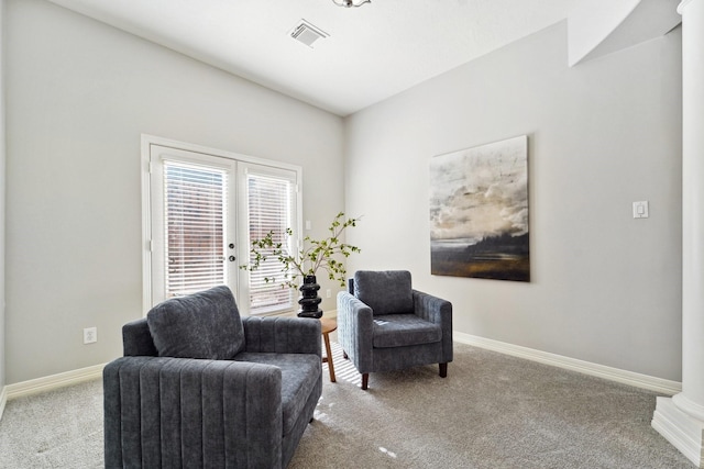 sitting room featuring french doors and light carpet