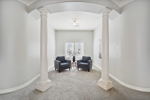 living area featuring ornate columns and carpet floors