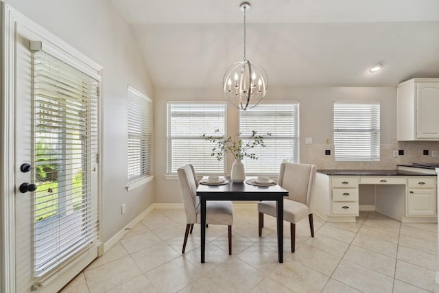 dining space with lofted ceiling, an inviting chandelier, and light tile patterned flooring