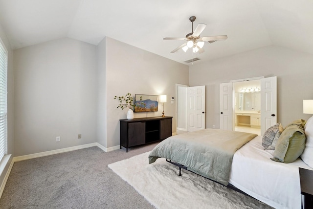 carpeted bedroom with ceiling fan, ensuite bathroom, and vaulted ceiling