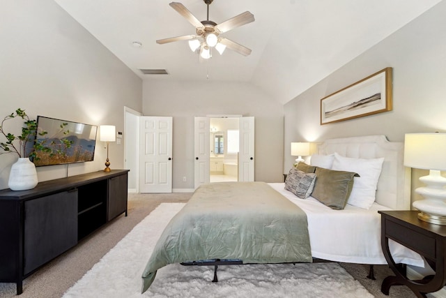 bedroom with ceiling fan, connected bathroom, vaulted ceiling, and light carpet