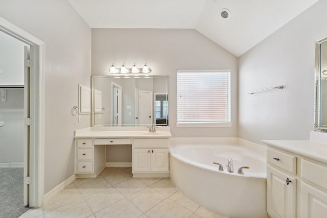 bathroom featuring lofted ceiling, tile patterned flooring, vanity, and a bathtub