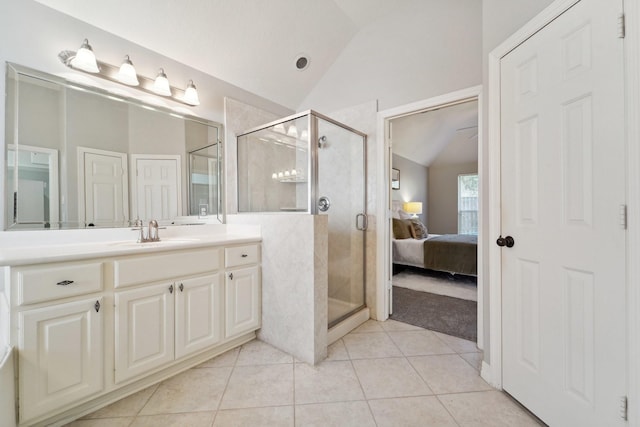 bathroom with a shower with door, vanity, lofted ceiling, and tile patterned floors