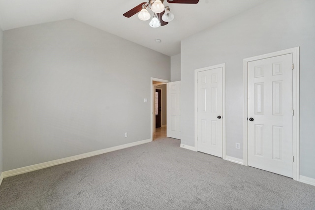 unfurnished bedroom with high vaulted ceiling, two closets, ceiling fan, and carpet flooring