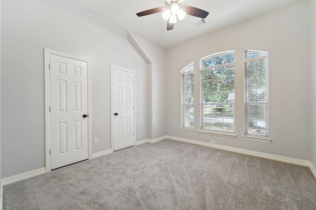 empty room with ceiling fan and light carpet