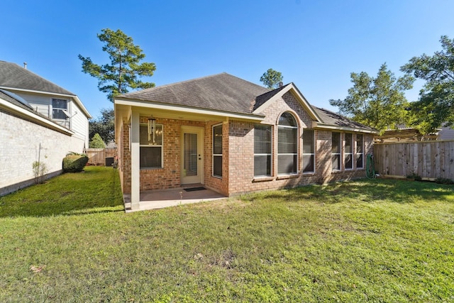 rear view of house with a patio and a lawn