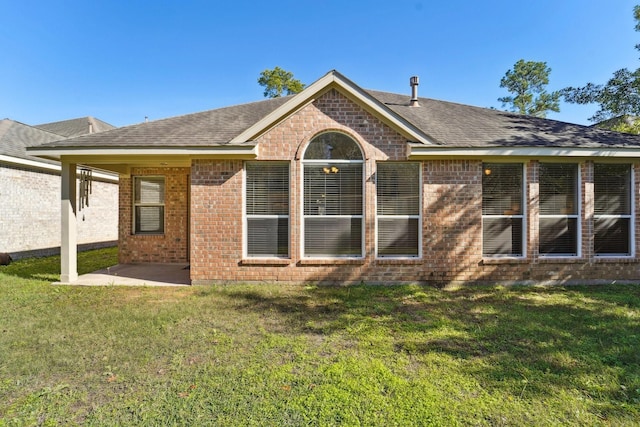 rear view of house with a patio and a yard