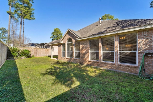 rear view of property featuring a yard