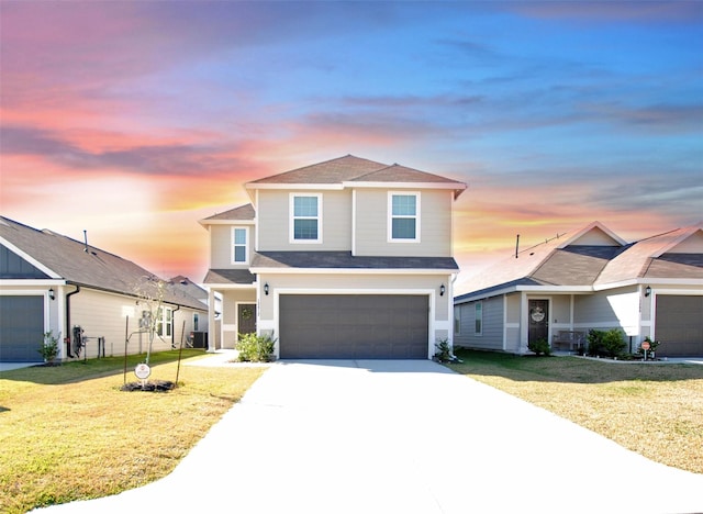 front facade featuring a garage and a yard