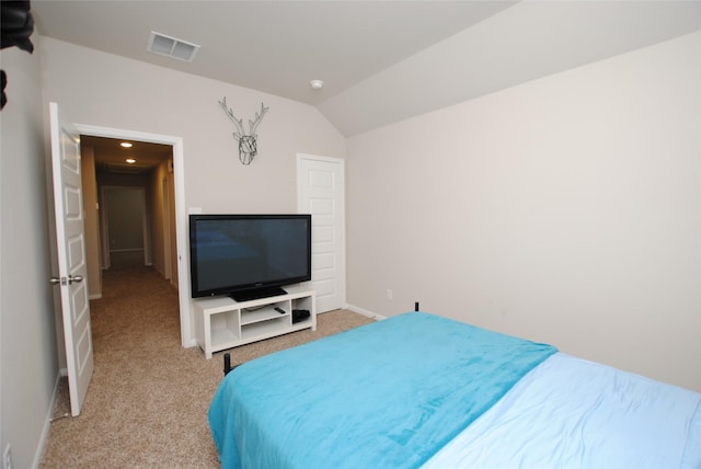 carpeted bedroom with lofted ceiling