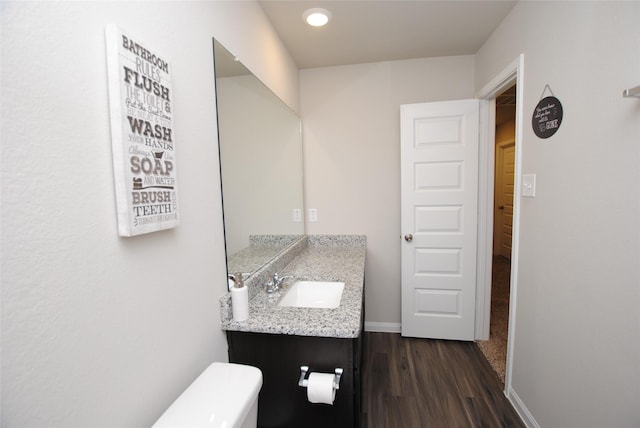 bathroom with vanity, wood-type flooring, and toilet