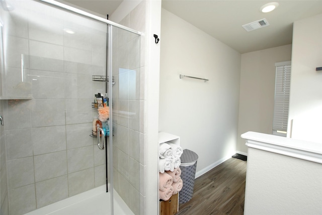 bathroom featuring hardwood / wood-style flooring and walk in shower