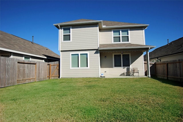 back of property with a yard and a patio